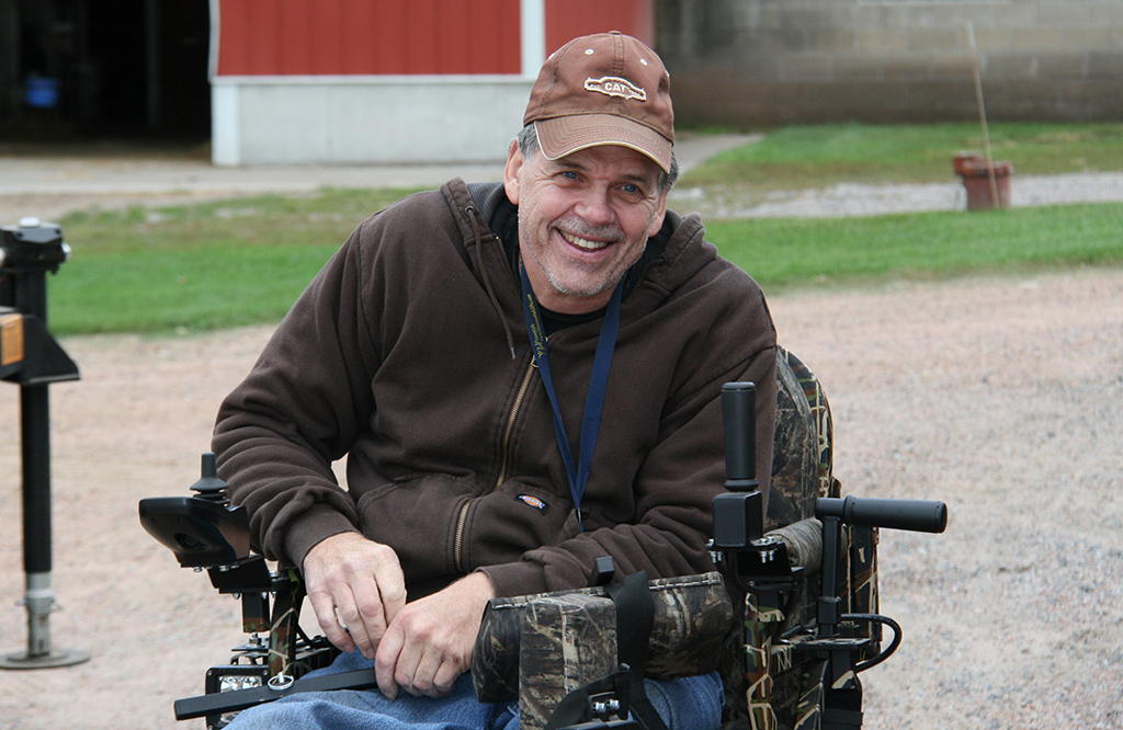 A farmer in a wheelchair by his barns